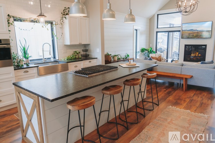 A kitchen with a black countertop and white cabinets.