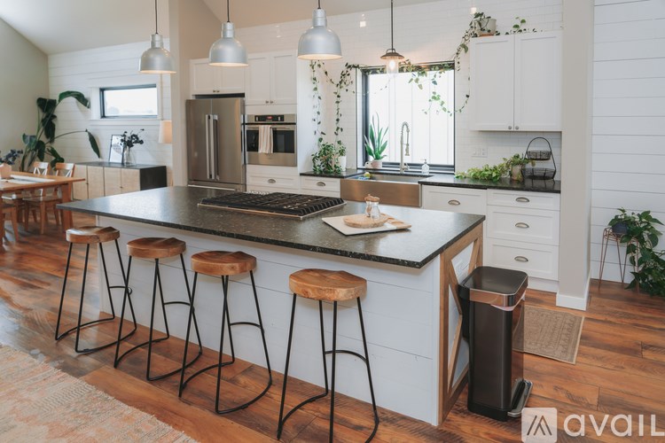 A kitchen with a black countertop and white cabinets.