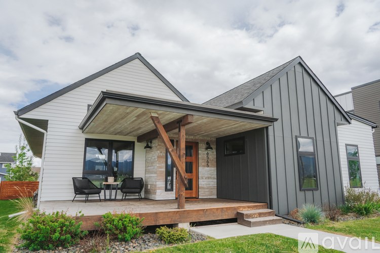 A modern house with a grey exterior and a wooden deck.