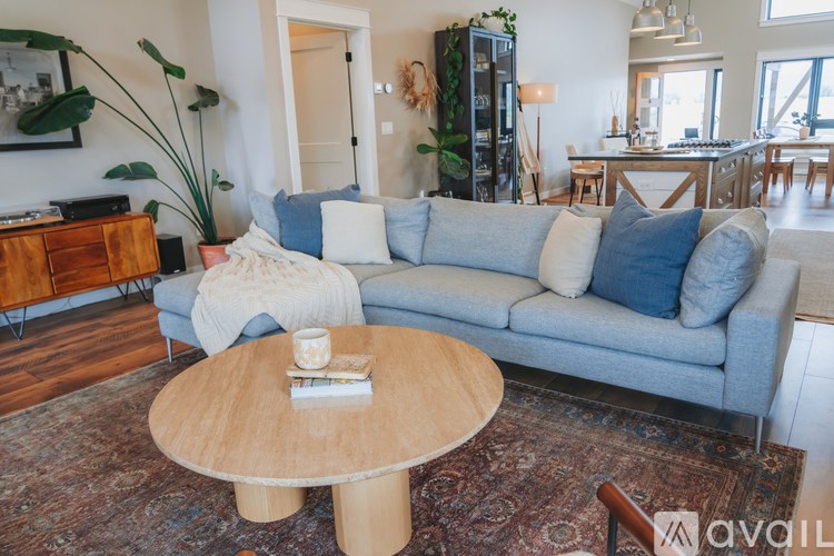 A living room with a grey couch, a wooden coffee table, and a rug.