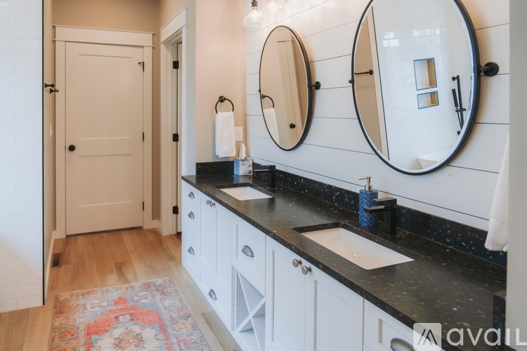 A bathroom with a sink, mirrors and cabinets.
