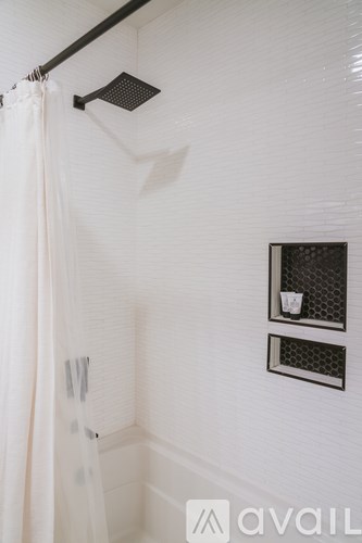 A white bathroom with a shower curtain and a shower head.