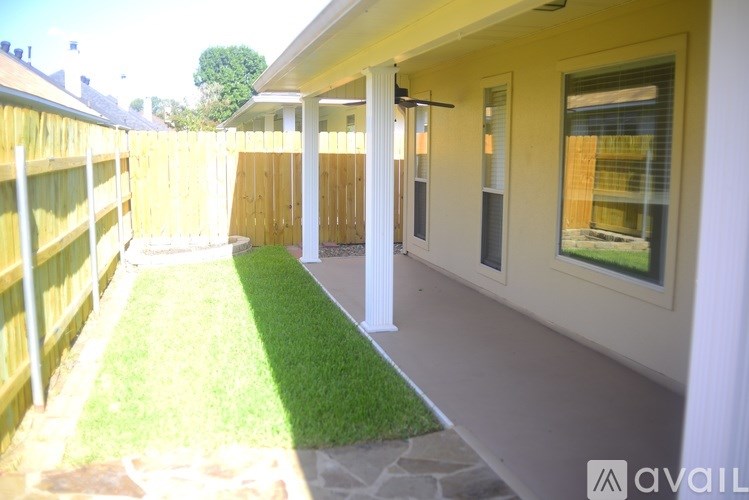 A backyard with a wooden fence and a small lawn.