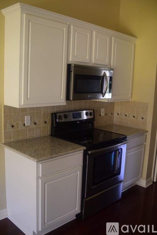 A kitchen with white cabinets and a black oven.