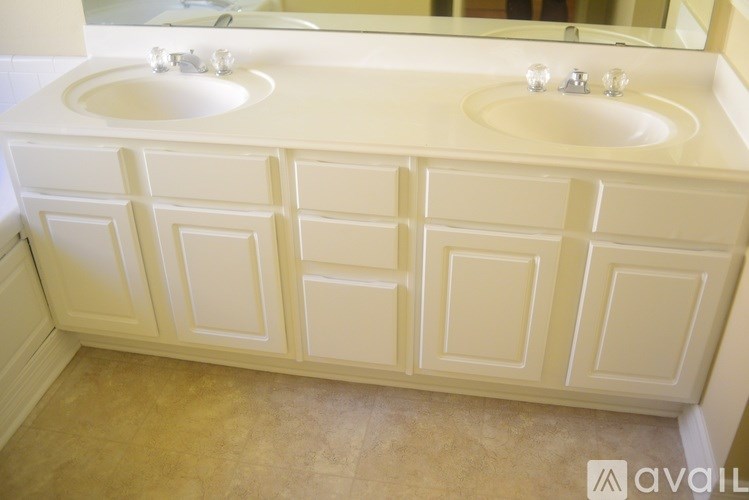 A bathroom vanity with two sinks and a mirror.