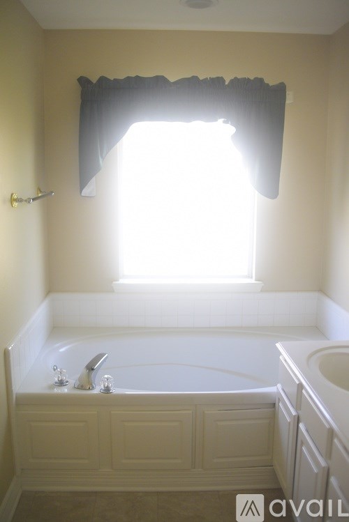 A bathroom with a tub and a window.