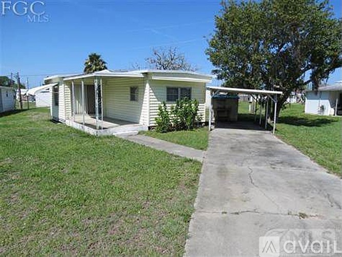 A mobile home with a concrete walkway leading to the front door.