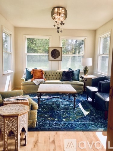 A living room with a green sofa and a chandelier.