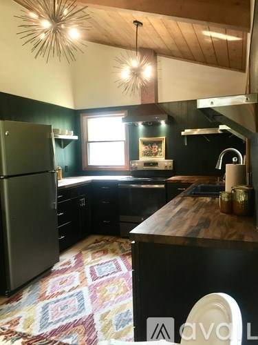 A kitchen with a wooden island and a refrigerator.