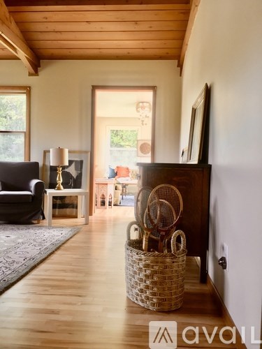 A room with a basket on the floor and a chair.