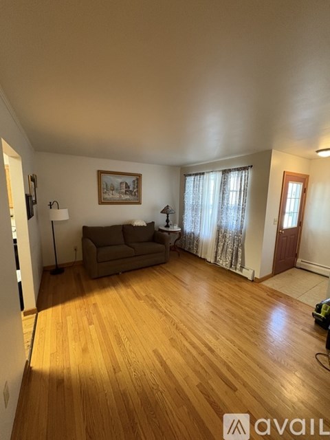 A living room with a couch and a painting on the wall.