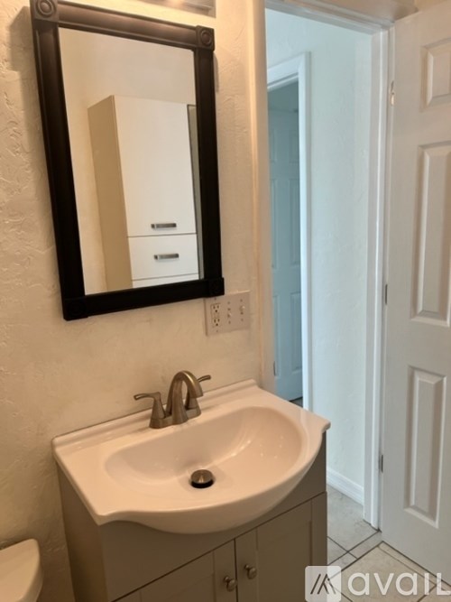 A bathroom with a sink, mirror and toilet.