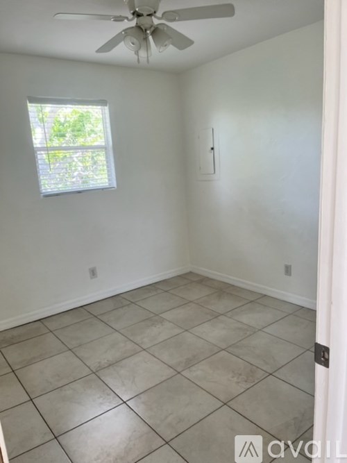 A room with a ceiling fan and a window.