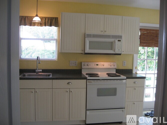 A kitchen with white appliances and cabinets.