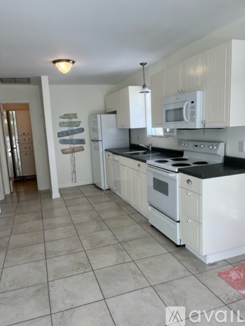 A kitchen with white appliances and cabinets.