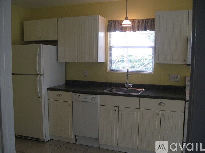 A kitchen with yellow walls and white appliances.