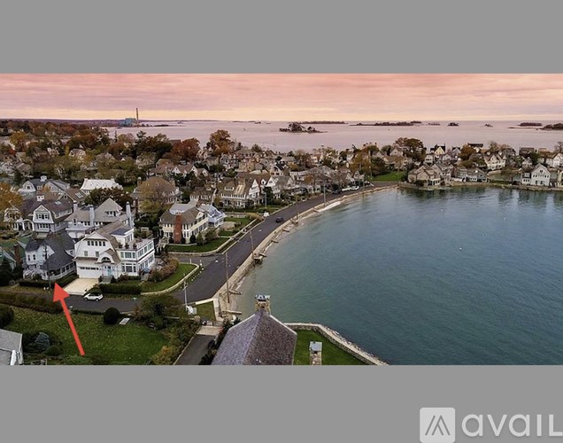 A red arrow points to a house in a coastal neighborhood.