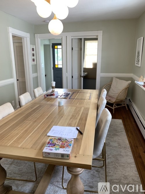 A dining room with a wooden table and chairs.