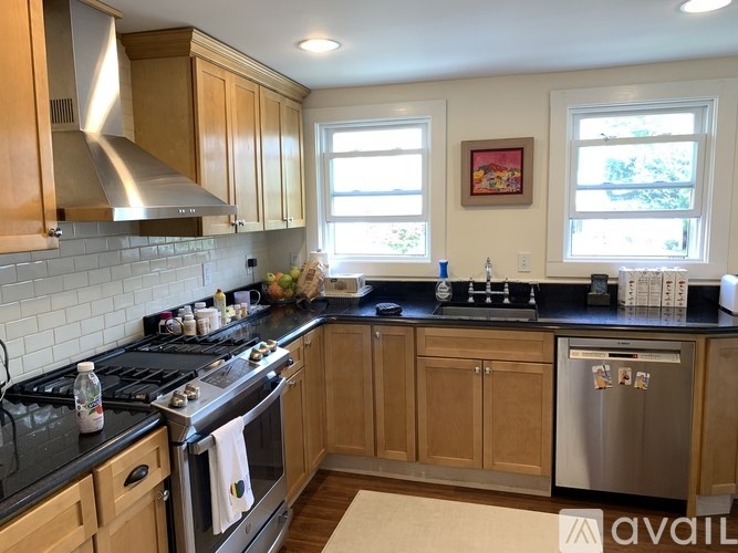 A kitchen with wooden cabinets and a black countertop.