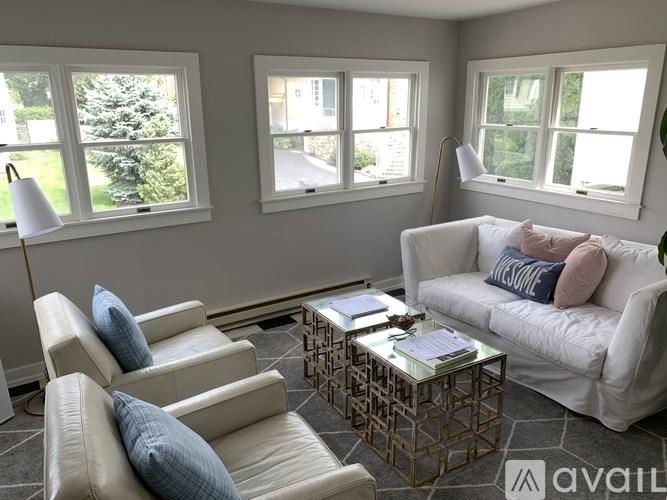 A living room with a white couch and a glass coffee table.