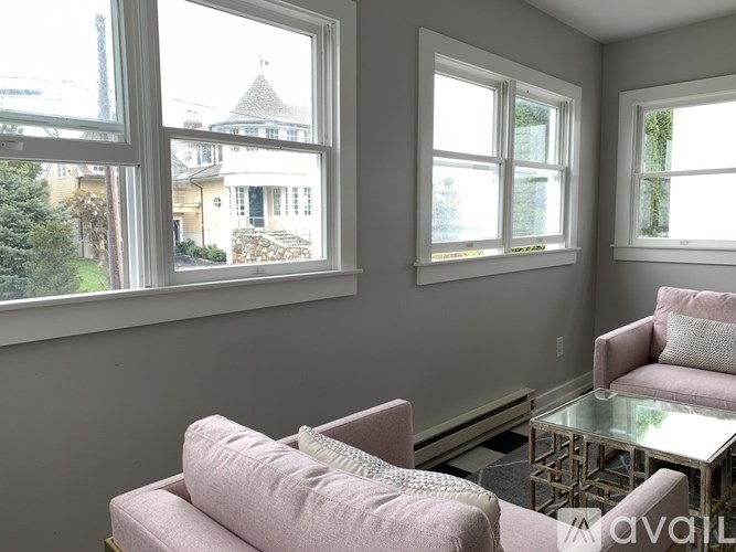 A living room with a couch, chair, and table in front of a window.