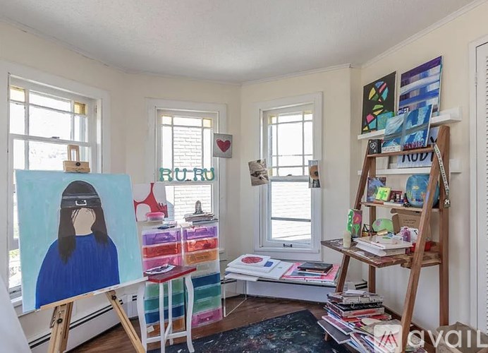 A room with a painting of a woman on a canvas on an easel.
