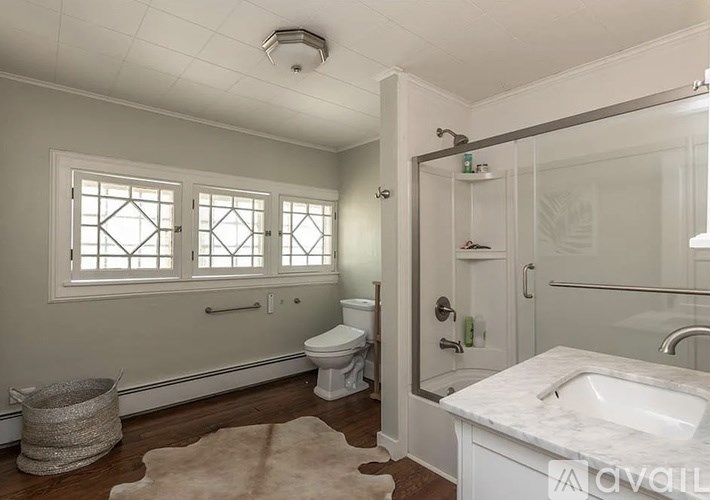 A bathroom with a toilet, sink, and shower.