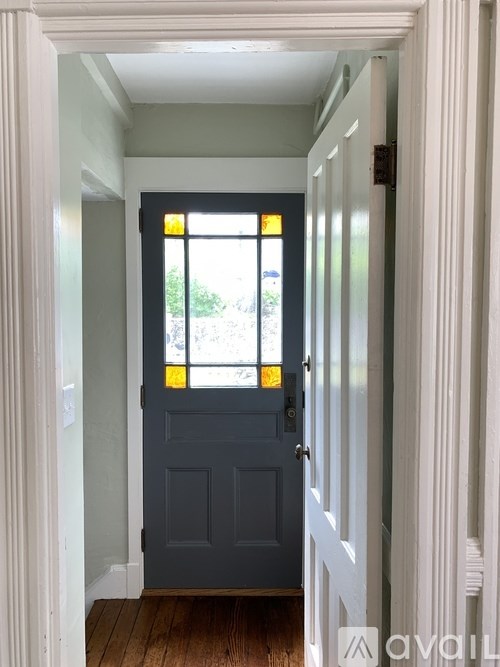 A door with a glass window and a black handle.