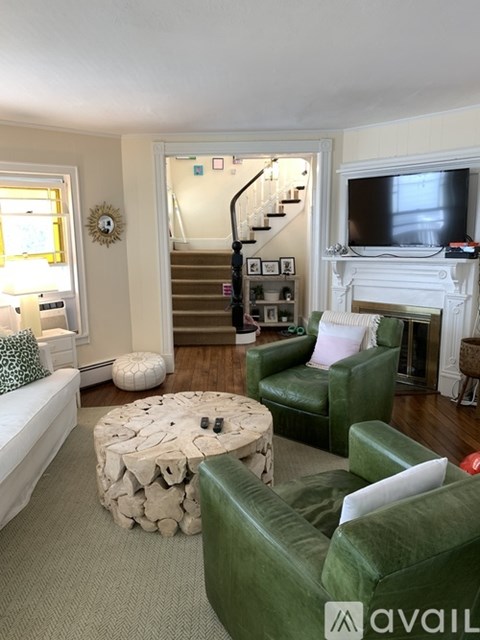 A living room with a green couch and a stone coffee table.