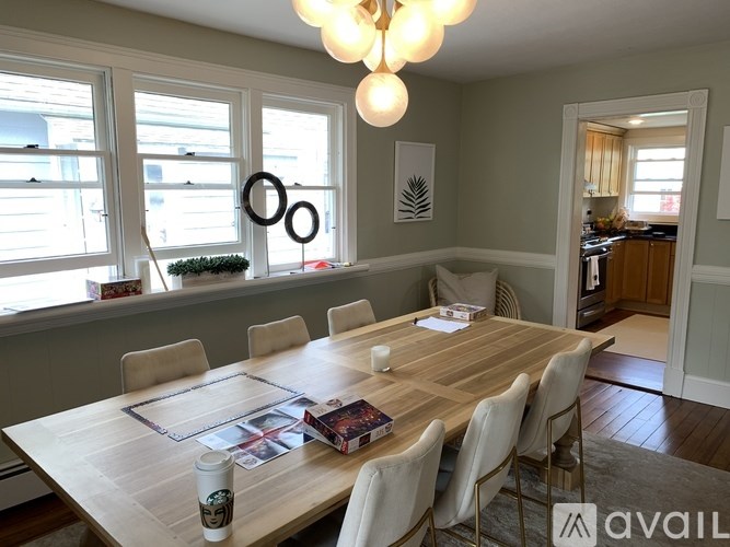 A dining room with a wooden table and chairs.
