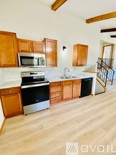 A kitchen with wooden cabinets and a stove top oven.