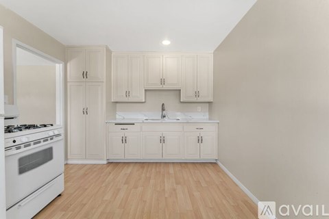 A kitchen with white appliances and cabinets.