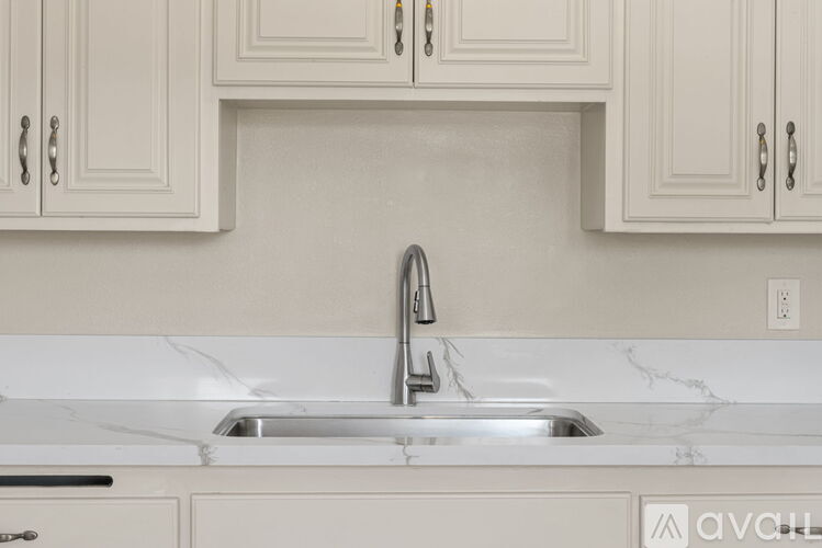 A kitchen with a marble countertop and a sink.