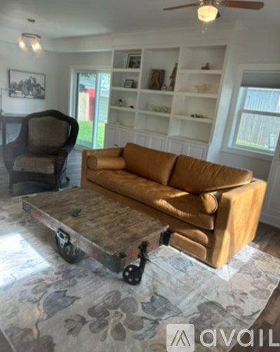 A living room with a brown couch and a black chair.