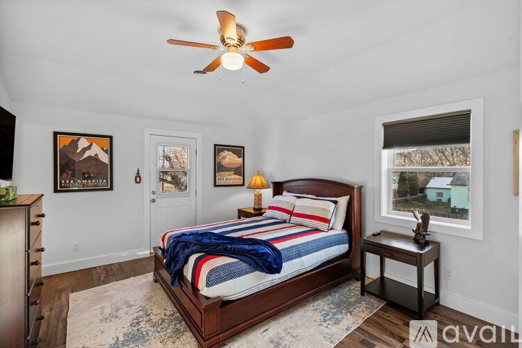 A bathroom with a toilet, a shower curtain, and a rug.
