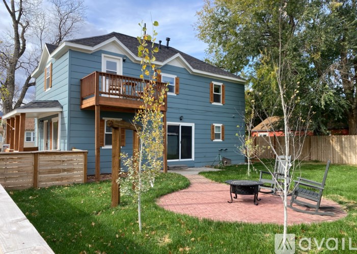 A blue house with a balcony and a small garden.