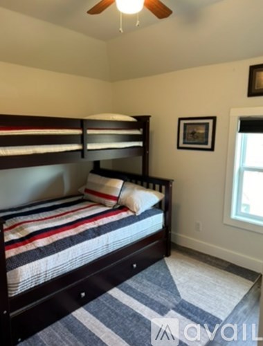 A bedroom with a bed and a ceiling fan.