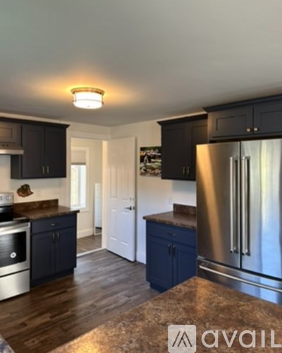 A kitchen with dark wood cabinets and a stainless steel refrigerator.