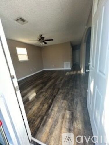 A room with wood flooring and a ceiling fan.