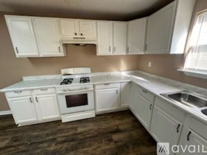 A kitchen with white cabinets and a stove top oven.
