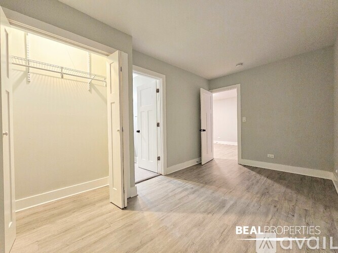 A spacious room with a white door and a white wall.