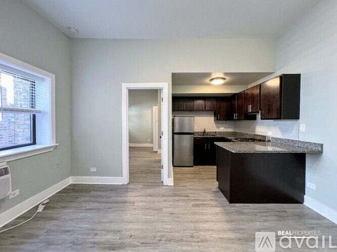 A kitchen with a granite countertop and wooden flooring.