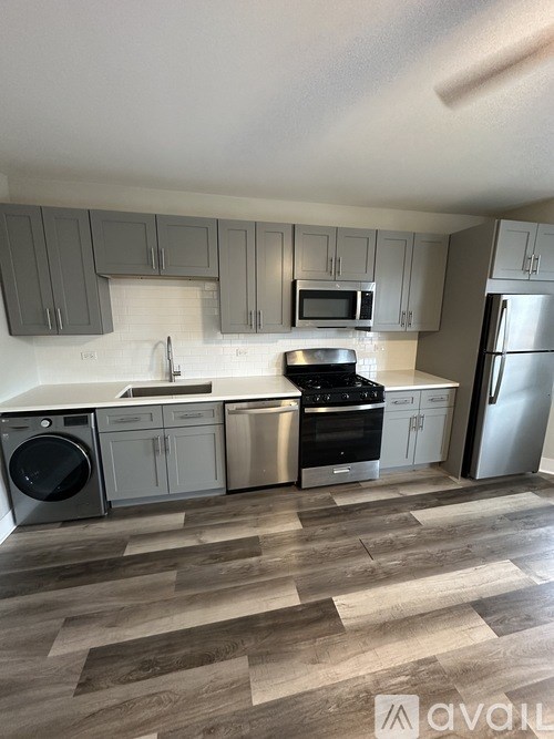 A kitchen with wooden floors and stainless steel appliances.