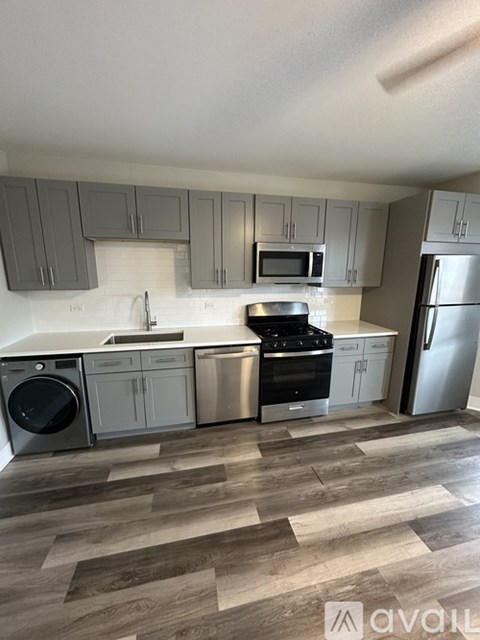 A kitchen with wooden floors and stainless steel appliances.