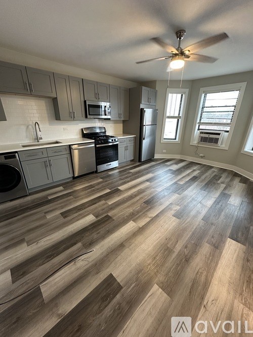 A kitchen with wooden flooring and a ceiling fan.