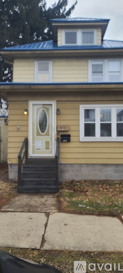 A yellow house with a white door and a small porch.