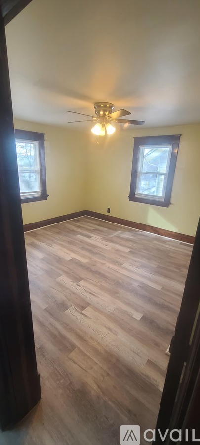 A room with wooden flooring and a ceiling fan.