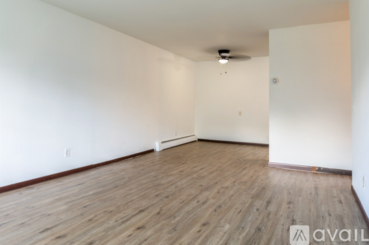 A room with wooden flooring and white walls.