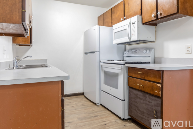 A kitchen with white appliances and wooden cabinets.