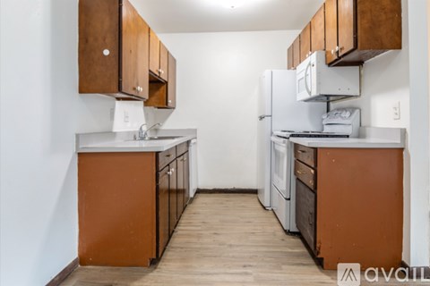 A kitchen with wooden cabinets and a white refrigerator.